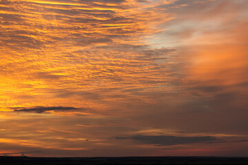 Dramatic fiery bloody sky. Fantastic golden sunset.