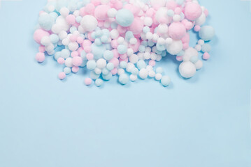 White, pink and blue soft pompons as a background.