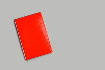 Libro rojo sobre fondo gris liso y aislado. Vista superior. Copy space