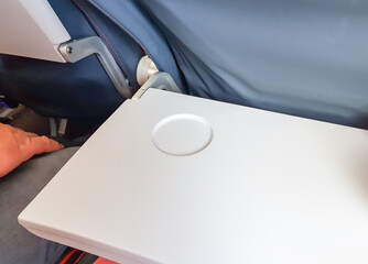 Open table for an airplane tray with a glass stand, close-up