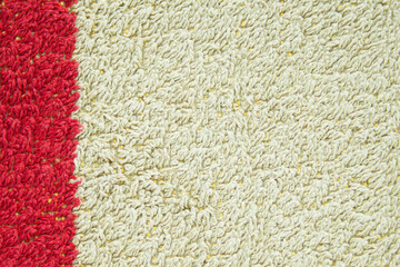 Gray-green terry cloth towels. On the left is a dark red, vertical stripe. The image can be used as a texture or background. Copy space.