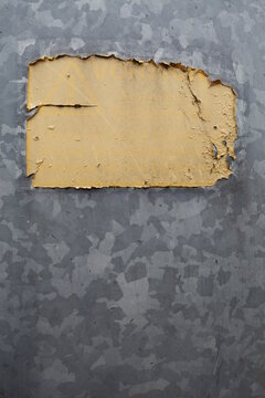 Eine gelbliche Farbfläche auf einem Untergrund aus Metall