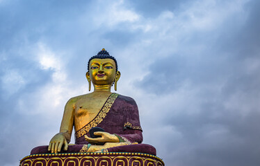 isolated huge buddha golden statue from different perspective with moody sky at evening