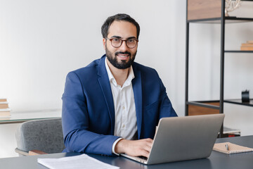 Mature arabian businessman freelancer financial advisor working online on laptop at office...