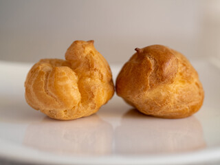 Two buns cakes on a white plate close up on a white background
