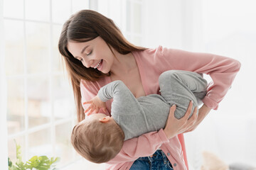 Young happy caucasian mother playing with her little small kid child. Nanny childminder lulling...