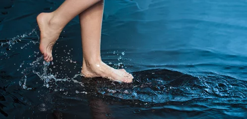 Rolgordijnen Woman foot step on blue Water in Splash © Chepko Danil