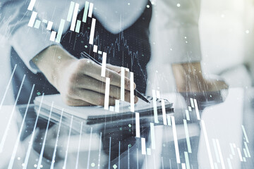 Double exposure of abstract creative financial chart with hand writing in notebook on background, research and strategy concept