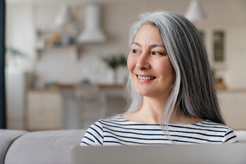 Fototapeta premium Close up happy middle-aged businesswoman tutor mother wife using laptop for e-learning, searching web, online shopping, remote freelance work, watching movies.