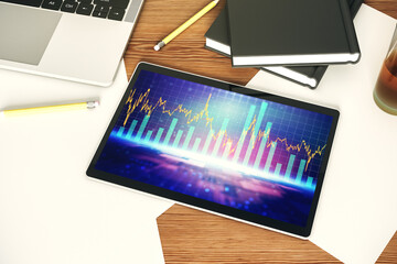 Modern digital tablet monitor with abstract creative financial chart, research and strategy concept. Top view. 3D Rendering