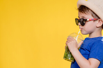 Summer refreshment. Cold beverage. Little boy with plastic cup of fresh lemonade