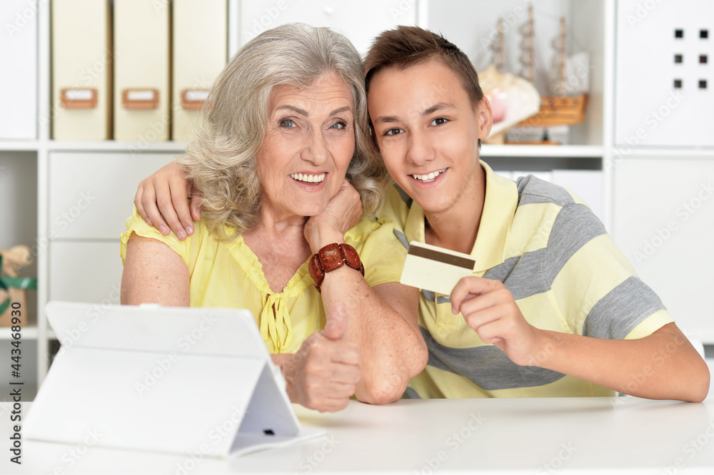 Wall mural Portrait of grandmother and boy using modern laptop shopping online