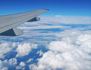 Obraz premium Viewed from airplane windows with a wing, blue sky and white cloud