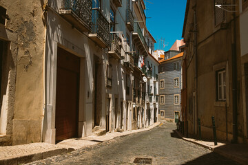 cute and colorful small alley in the european city of Lisbon in Portugal, with examples of classic poortuguese architecture. Tourist season sightseing is very popular during summer season in the city.