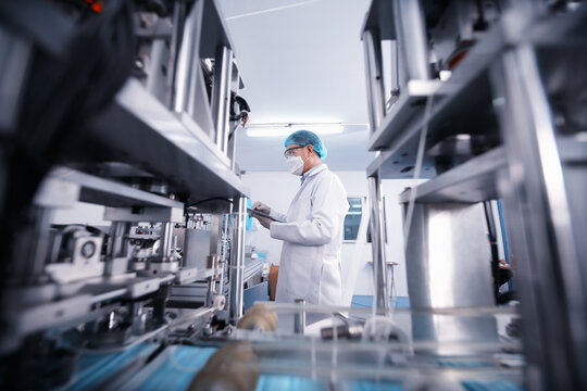 Quality control worker analyzing manufacturing machine in laboratory.