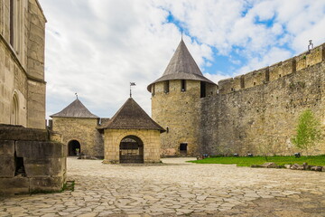Courtyard and part of the wall of old castle Hotel near the river. Khotyn Fortress - medieval castle on yellow autumn hills. Ukraine, Eastern Europe. The architecture of the Middle Ages in our time.