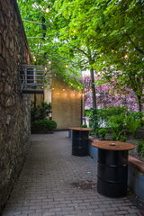 Cozy courtyard with barrel-shaped tables. A small cafe tucked away in an alley in a big city in a spring shunny day. Kiev. Ukraine