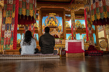 Obraz na płótnie Canvas couple meditating isolated inside buddhist monastery at morning from low angle