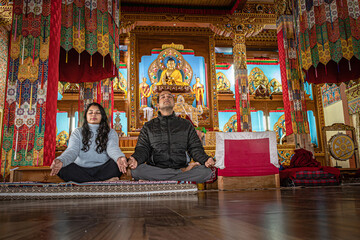 couple meditating isolated inside buddhist monastery at morning from low angle
