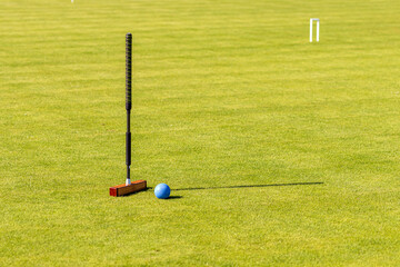 croquet mallet and ball on a lawn