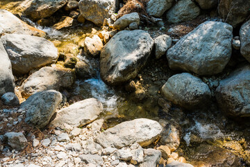 Fototapeta na wymiar A mountain stream scenery, water flowing over rocks.