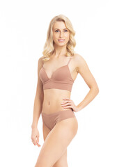 Obraz premium Beautiful and slender woman posing over white background in studio. Caucasian model in brown swimsuit. Dieting and fitness concept.