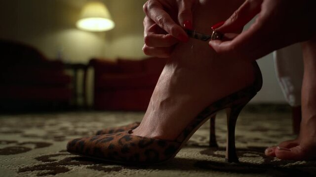 Close-up of young woman buttons lock high heels shoes. Woman's leg in high heel shoes. Romantic. Close up. 4k