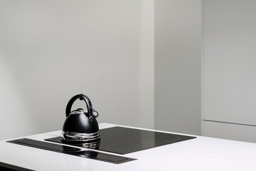 Countertop with black kettle on induction stove top