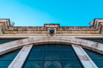Fototapeta premium Close-up low agle view of arch in the facade of a Cathedral. Symmetric view against blue sky. Madrid, Spain