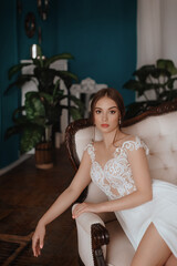 Beautiful bride with light make-up in white dress  in an exquisite interior 