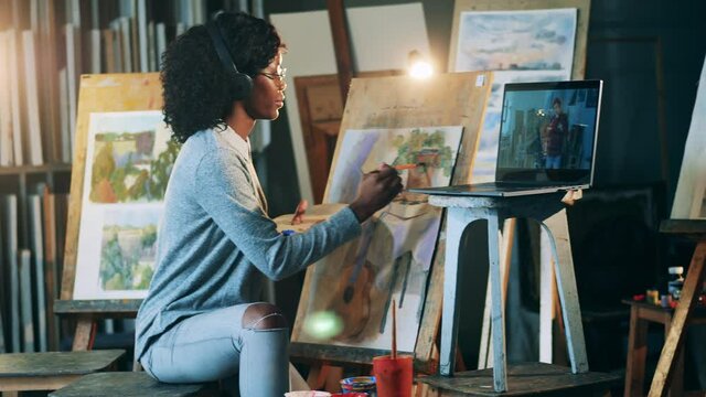 African-american woman is having a remote painting class. Art education concept.