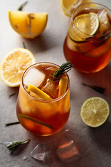 Cold drink with lemon, lime, ice, and rosemary.