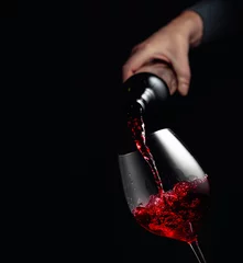 Gordijnen Rode wijn gieten in een glazen beker. © Igor Normann