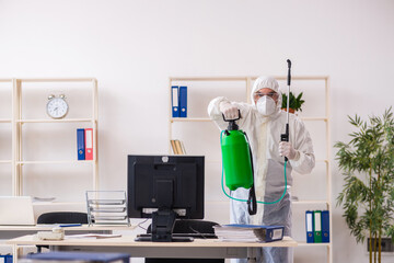 Old male contractor in office disinfection concept