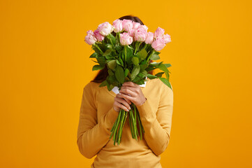 Young woman holding bouquet of roses, birthday