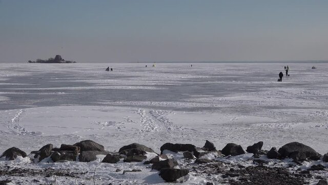Kronstadt forts fortification islands near Saint-Petersburg in ice at winter. Ice fishing fisherman. snow dunes. High quality 4k panoramic footage
