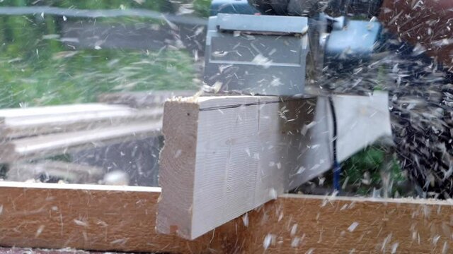 a man processes boards with an electric plane