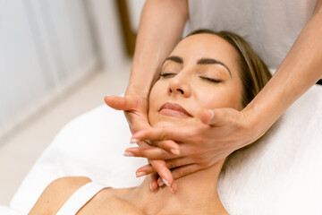Fototapeta na wymiar Middle-aged woman having a head massage in a beauty salon.