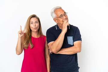 Middle age couple isolated on white background standing and thinking an idea