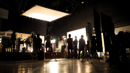 Video production in big studio set. Behind the scenes concept. video production team in silhouette...