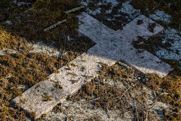 A stone cross on a tombstone in a cemetery.