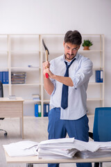 Young male employee unhappy with excessive work in the office