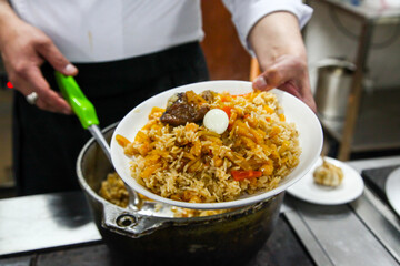 Chef preparing traditional central Asian dish - pilaf