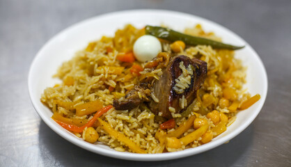 Traditional central Asian dish - pilaf from rice, vegetables, and beef on a plate