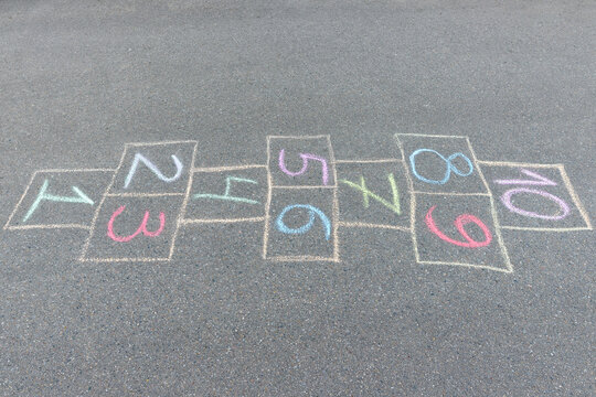 Close-up photo of chalk painted hopscotch on asphalt. School yard. Back to school.