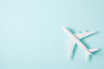 Flat lay design of travel concept with plane on light blue background.