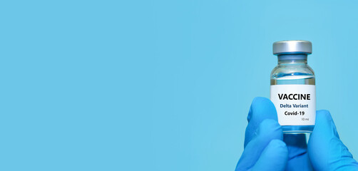 A doctor in medical gloves holds a bottle with coronavirus Covid19 Delta variant strain vaccine.The concept of medicine, healthcare and science.Coronavirus vaccine