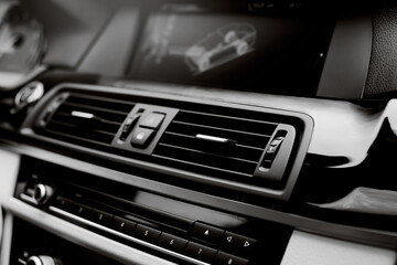 Close up Air Vent in modern car. Ventilation vents with air flow deflectors and display. - obrazy, fototapety, plakaty