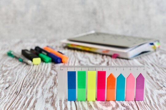 Stationery, colored self-adhesive labels in the foreground on a wooden table, business still life