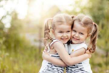 Little girls twins hug each other. Wonderful emotions
